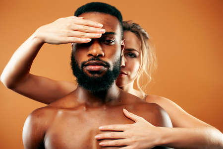 Young pretty couple diverse races together posing sensitive on brown background, lifestyle people conceptの写真素材