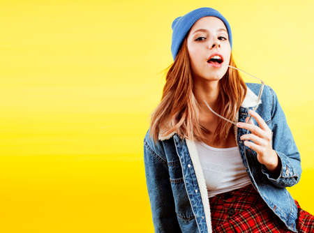 lifestyle people concept: pretty young school teenage girl having fun happy smiling on yellow backgroundの写真素材