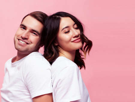 young cheerful caucasian couple together having fun on pink background, guy ang girl modern relationship, lifestyle people conceptの写真素材