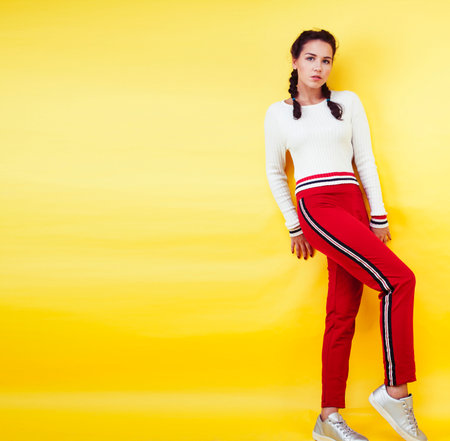 lifestyle people concept: pretty young school teenage girl having fun happy smiling on yellow backgroundの写真素材