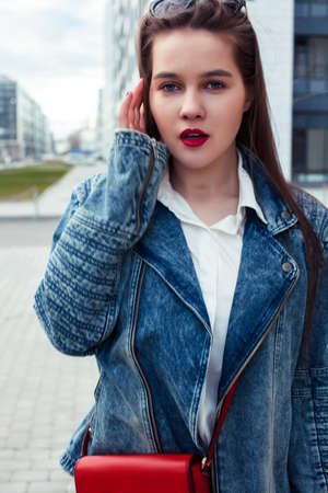 young pretty brunette business woman posing emotional against modern building in glasses holding coffee, lifestyle people conceptの写真素材