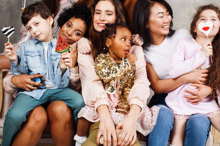 Lifestyle and people concept: young pretty diversity nations woman with different age children celebrating on birth day party together happy smiling, making selfie. African-american, asian and caucasian close upの写真素材