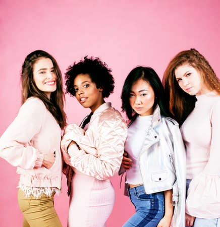 different nation girls with diversuty in skin, hair. Asian, scandinavian, african american cheerful emotional posing on pink background, woman day celebration, lifestyle people conceptの写真素材