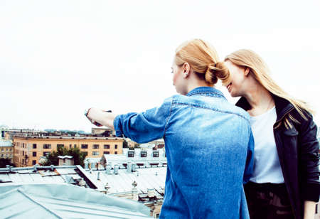 two cool blond real girls friends making selfie on roof top, lifestyle people concept, modern teensの写真素材