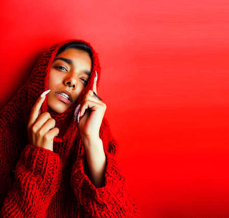 young pretty indian girl in red sweater posing emotional, fashion hipster teenage, lifestyle people conceptの写真素材