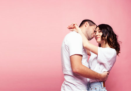 young cheerful caucasian couple together having fun on pink background, guy ang girl modern relationship, lifestyle people conceptの写真素材