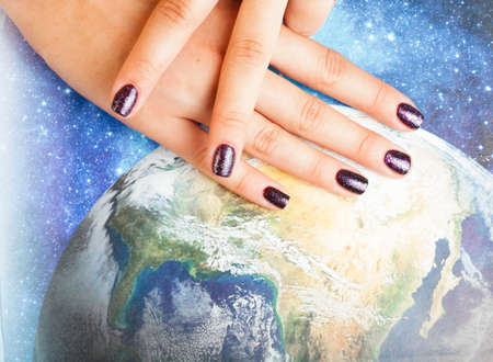 manicure stylish concept: woman fingers with nails purple glitter on nails like cosmos, universe backgroundの写真素材
