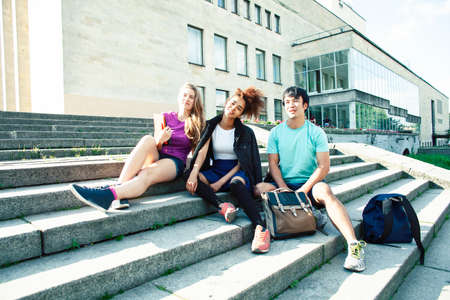 cute group of teenages at the building of university with books huggings, diversity nations, having lunchの写真素材