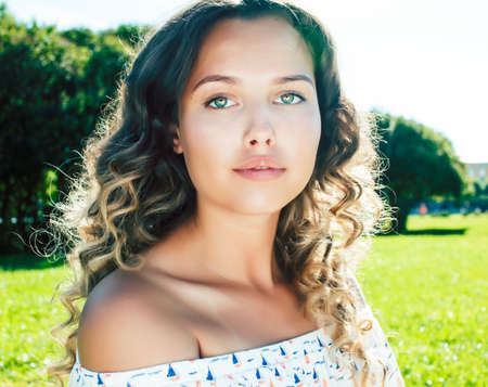 young cute summer girl on green grass outside relaxing smiling, lifestyle people concept