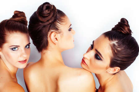 tree pretty stylish young woman with same hairstyle and makeup posing isolated on white background,...