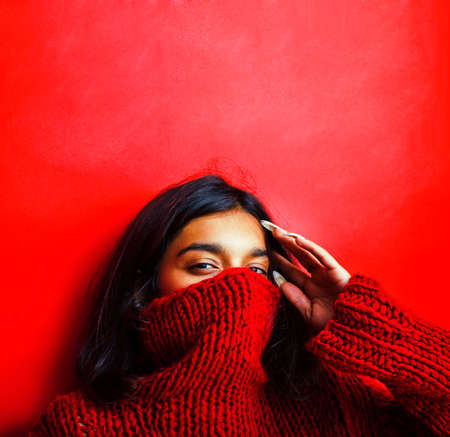 young pretty indian girl in red sweater posing emotional, fashion hipster teenage, lifestyle people conceptの写真素材
