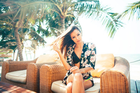 young pretty woman at swimming pool relaxing in chair, fashion look in lingerie at hotel, lifestyle people conceptの写真素材