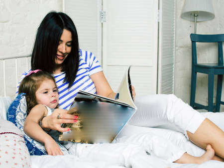 young mother with daughter at home playing, happy familyの写真素材