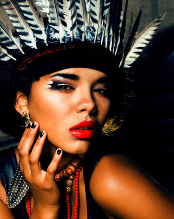 young pretty woman with make up like red indian, futher in hair, fashion hallowen concept