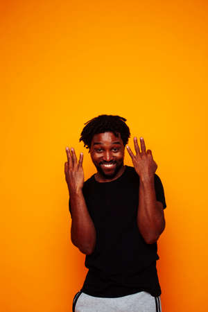 young handsome african american guy student posing cheerful and gesturing on yellow background, lifestyle people conceptの写真素材