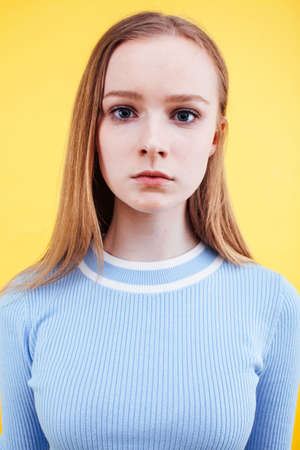 young pretty teenage girl emotional posing on yellow background, fashion lifestyle people conceptの写真素材