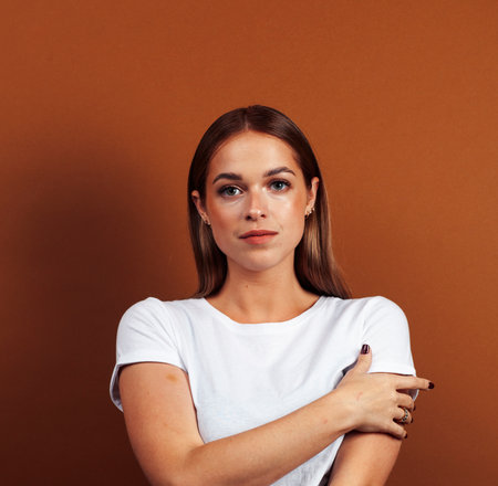 young pretty girl with blond hair posing cheerful on brown background, lifestyle people conceptの写真素材