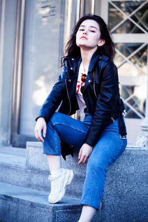 young pretty asian girl wearing leather jacket outside on big city street, lifestyle people concept