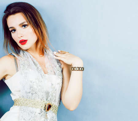 young pretty woman with blond hair on blue background, sensual make up elegant look