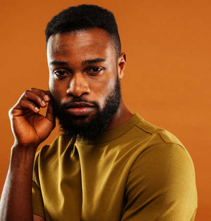 young pretty african american man posing cheerful on brown background, lifestyle people concept