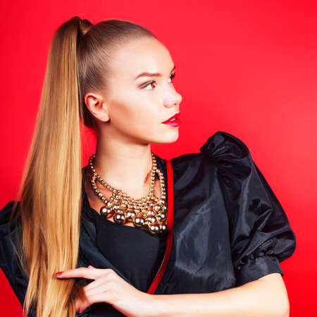 young pretty woman young lady posing on red background, lifestyle people conceptの写真素材