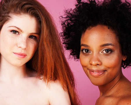 different nation girls with diversuty in skin, hair. scandinavian, african american cheerful emotional posing on pink background, woman day celebration, lifestyle people conceptの写真素材