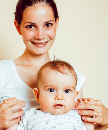 young brunette happy mother holding toddler baby son, breast-feeding concept, people lifestyleの写真素材
