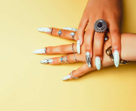 woman hands holding colorful paper copyspace wearing a lot of jewelry and long nails
