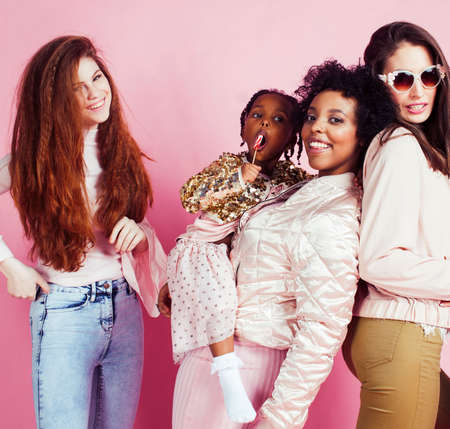 different nation girls with diversuty in skin, hair. Asian, scandinavian, african american cheerful emotional posing on pink background, woman day celebration, lifestyle people conceptの写真素材