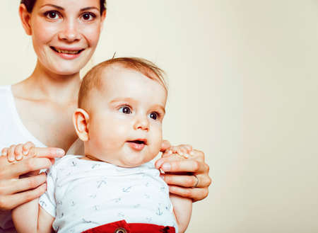 young brunette happy mother holding toddler baby son, breast-feeding concept, people lifestyleの写真素材