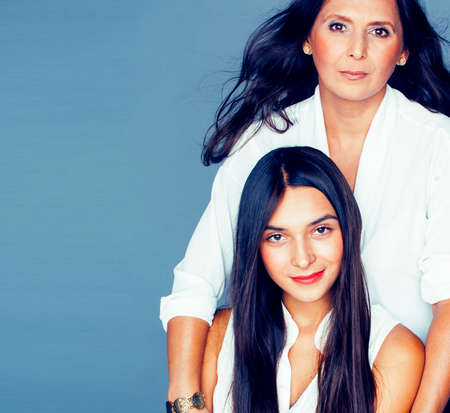 cute pretty teen daughter with mature mother hugging, fashion style brunette, lifestyle people conceptの写真素材