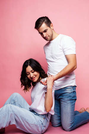 young cheerful caucasian couple together having fun on pink background, guy ang girl modern relationship, lifestyle people conceptの写真素材