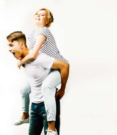 young pretty teenage couple, hipster guy with his girlfriend happy smiling and hugging isolated on white background, lifestyle people conceptの写真素材