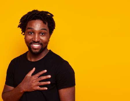 young handsome african american guy student posing cheerful and gesturing on yellow background, lifestyle people conceptの写真素材