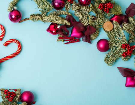 christmass stuff laying flat on colorful background, branch of tree, balls, candyの写真素材