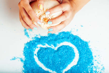 manicure with blue nails and seasalt close up like heart, love for summerの写真素材