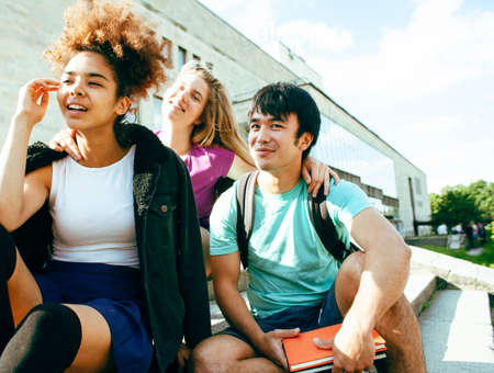 cute group of teenages at the building of university with books huggings, diversity nations, having lunch closeupの写真素材