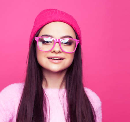 young pretty girl with brunette long hair posing cheerful on pink background, lifestyle people conceptの写真素材