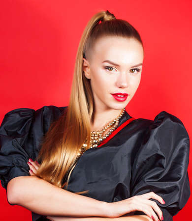 young pretty woman young lady posing on red background, lifestyle people conceptの写真素材