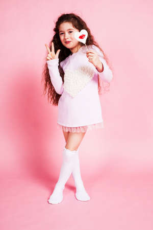 little cute girl with candy on pink background posing emotional, lifestyle people conceptの写真素材