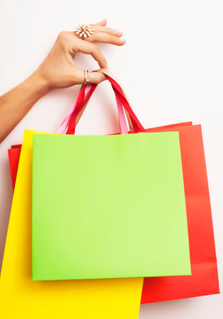 woman hand holding few paper bags on white background isolated, shopping sale conceptの写真素材