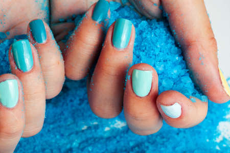 manicure with blue nails and seasalt close up like heart, love for summerの写真素材