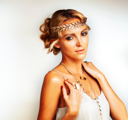 young blond woman dressed like ancient greek godess, gold jewelry closeup isolated, beautiful girl hands manicured red nailsの写真素材