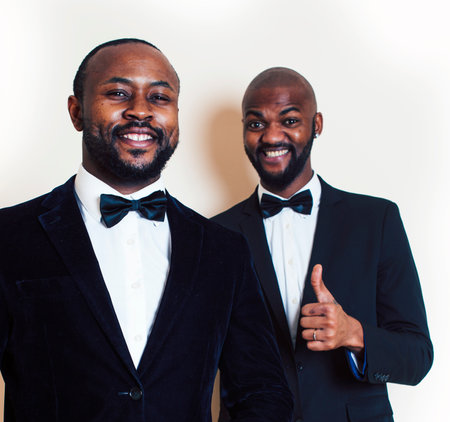 two african-american businessmen in black suits emotional posing, gesturing, smiling. wearing bow-tiesの写真素材