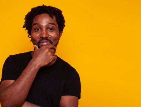 young handsome african american guy student posing cheerful and gesturing on yellow background, lifestyle people conceptの写真素材
