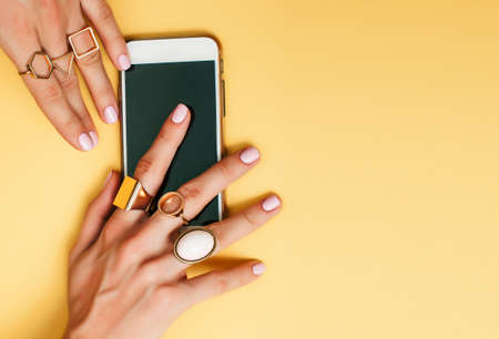 womans hand taking picture of her new manicure with fashion jewelryの写真素材