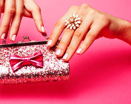 little girl stuff for princess, woman hands holding small cute handbag with jewelry and manicure, luxury lifestyle conceptの写真素材