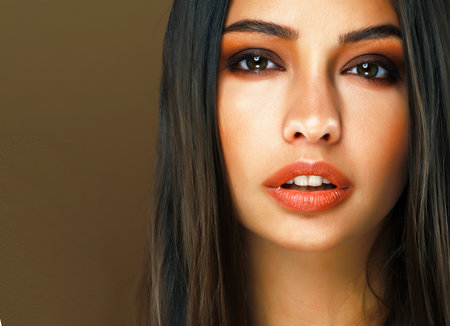 cute happy young indian woman in studio closeup smiling on brown background, fashion beauty lifestyle people conceptの写真素材