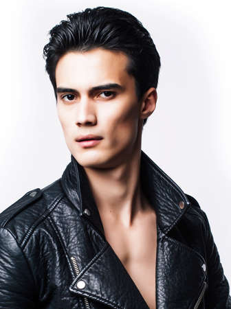 young handsome man, leather jacked on naked torso, emotional posing, white background, modern guy, lifestyle people conceptの写真素材