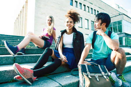 cute group of teenages at the building of university with books huggings, diversity nations, having lunchの写真素材